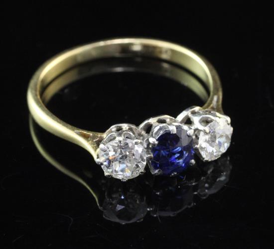 An 18ct gold and three stone sapphire and diamond ring, size O.